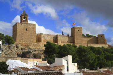 Antik Alcazaba kalesi ve kilise çan kulesi İspanya 'nın Antequera kentindeki beyazlatılmış büyüleyici köyün üzerindeki manzaraya hükmediyor..