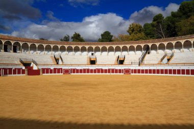 Boş bir İspanyol boğa güreşi arenası kemerli galerilerini, katlı koltuklarını ve kumlu çukurunu sergiliyor. Toros de Antequera Meydanı