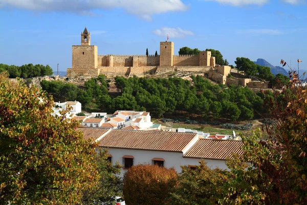 Antik Alcazaba kalesi ve kilise çan kulesi İspanya 'nın Antequera kentindeki beyazlatılmış büyüleyici köyün üzerindeki manzaraya hükmediyor..