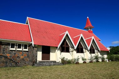 Krem rengi büyüleyici bir kilise Notre Dame Auxiliatrice çarpıcı kırmızı kiremitli çatısı ve iki farklı çan kulesi