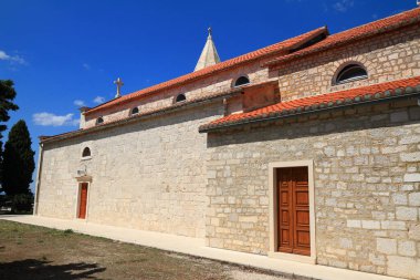 Hırvatistan 'ın Primosten kentindeki görkemli Aziz George Kilisesi açık mavi bir gökyüzünün altında dimdik ayakta duruyor.