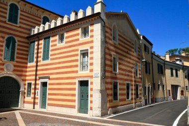 Garda Gölü 'nde çizgili tuğla cepheli geleneksel İtalyan mimarisi seyahat broşürleri, gayrimenkul ve kültür turizmi içeriği için ideal..