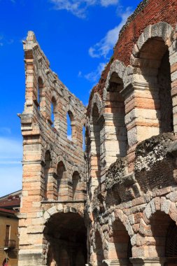 Verona 'daki tarihi Roma amfi tiyatrosu berrak mavi gökyüzü altında, seyahat, tarih ve kültür projeleri için ideal.