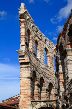 İtalya 'nın Verona kentindeki tarihi Roma amfitiyatrosunda sıcak güneş ışığı ve açık gökyüzü ile antik mimari sergileniyor. Seyahat, tarih ve kültür projeleri için ideal.