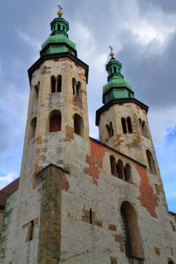 Yeşil bakır kubbeli iki görkemli tarihi kilise kulesi dramatik bulutlu gökyüzüne karşı dimdik ayakta duruyor. Antik Avrupa mimarisi ihtişamı ve zengin mirası sergiliyorlar..