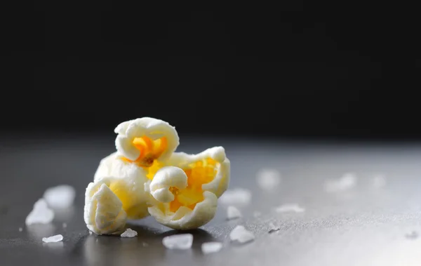 Einzelnes Popcorn isoliert auf schwarzem Hintergrund — Stockfoto