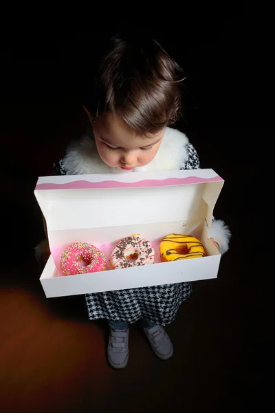 Little girl with sweet different donuts — Stock Photo, Image