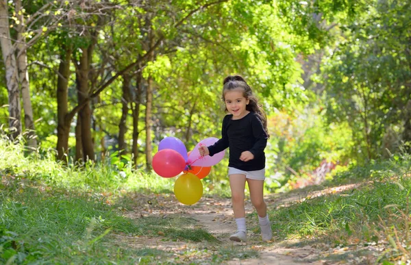 Liten flicka som leker i höst park — Stockfoto