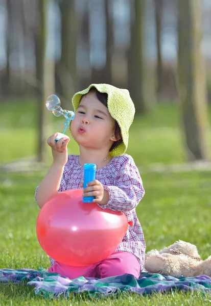 小さな女の子がシャボン玉を吹いています。 — ストック写真