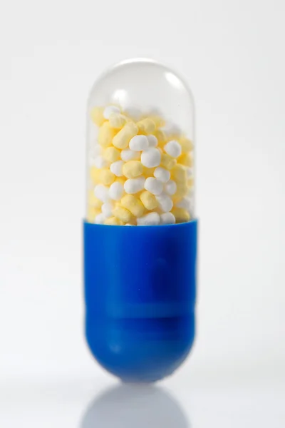 Pill capsule with colorfull granules — Stock Photo, Image