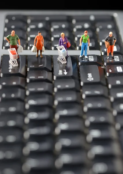 Miniature shoppers with shopping cart — Stock Photo, Image