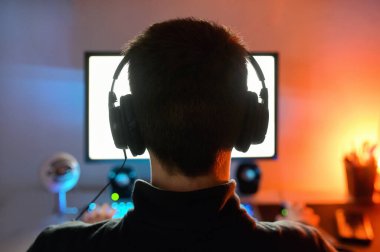 Arkadan video oyunu oynayan genç adam.