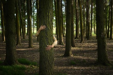 Abstract Young woman Hugging Tree in Forest 