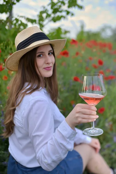 若いです女性でローズワインでガラスの上にケシ畑 — ストック写真
