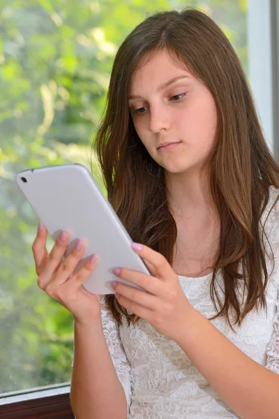 Menina jovem lendo informações em um computador tablet — Fotografia de Stock