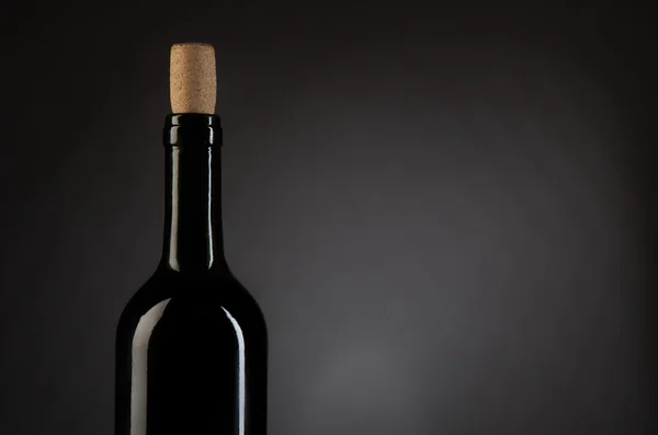 Fles wijn op donkere studio achtergrond — Stockfoto