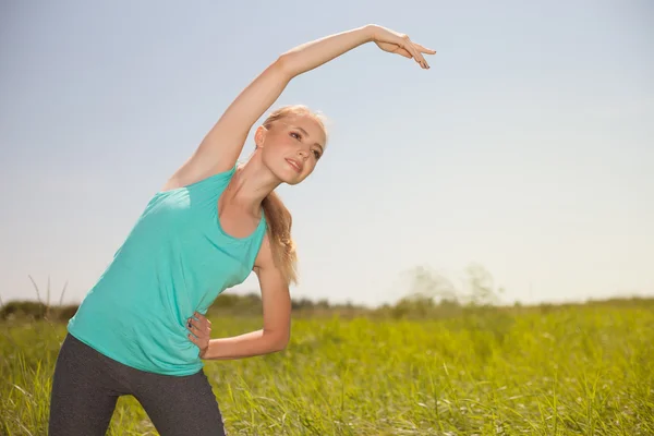 Belleza deportiva rubia joven haciendo ejercicio al aire libre yoga — Foto de Stock