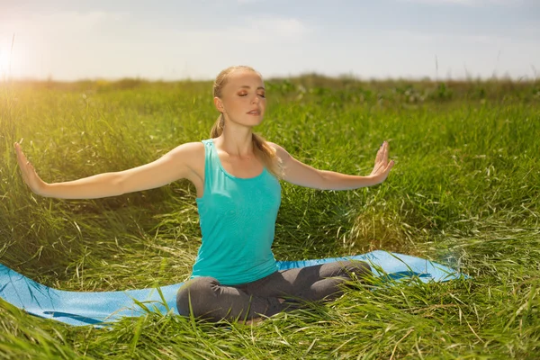 Fredlig friska passar blond ung kvinna mediterar på natur — Stockfoto