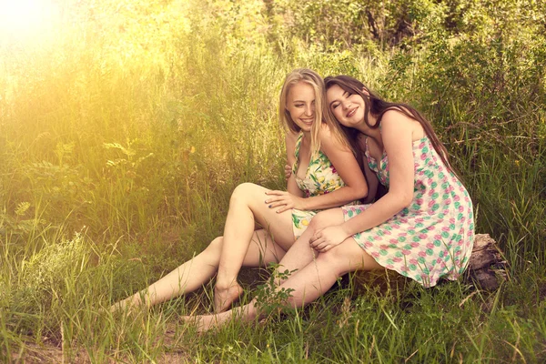 Dwóch przyjaciół happy umiejscowienia na trawie i uśmiech — Zdjęcie stockowe