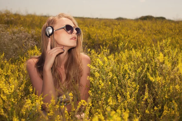 Jovem loira com fones de ouvido ao ar livre campo desfrutando de música — Fotografia de Stock