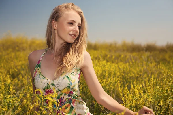 Blonde sexy mooi meisje in het veld gele bloemen — Stockfoto