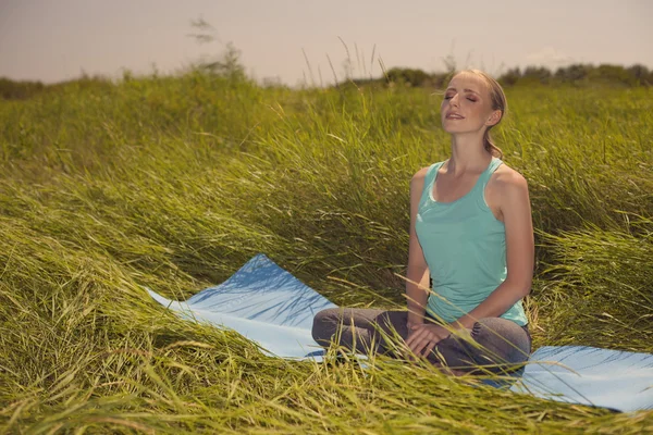 Genç kadın gözleri kapalı doğa üzerinde meditasyon — Stok fotoğraf