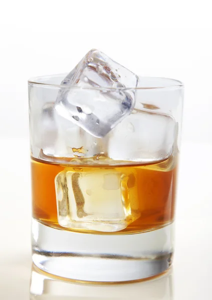 Whiskey with ice cubes in glass on white bg — Stock Photo, Image