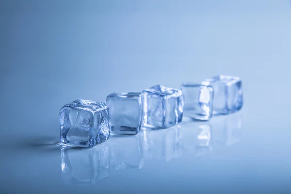 Ледяные кубики на синем фоне — стоковое фото