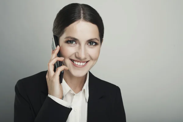 Geschäftsfrau telefoniert isoliert vor grauem Hintergrund — Stockfoto