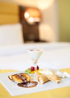 Meyve ve bir yatakta otelde çikolata çöller