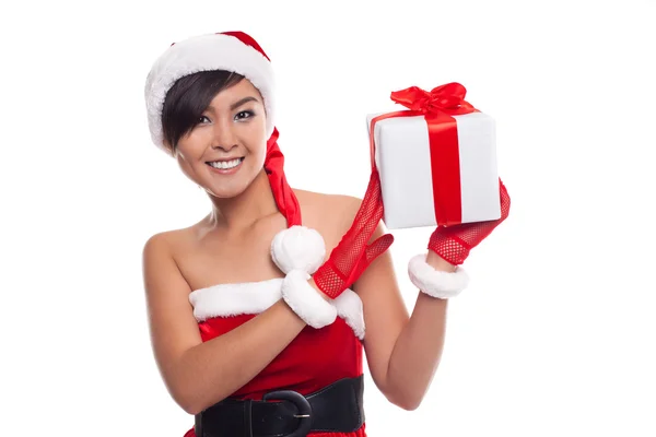 Young woman with Santa hat holding Christmas gift against white — Stock Photo, Image