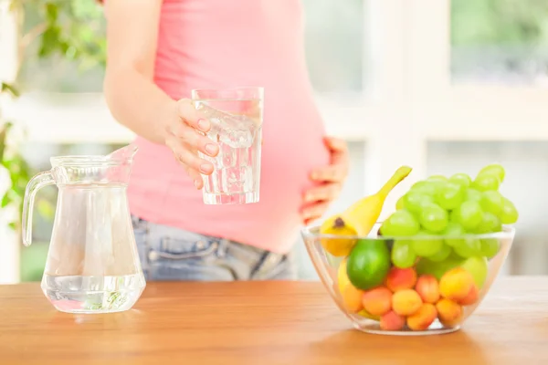 Donna incinta che beve un bicchiere d'acqua — Foto Stock