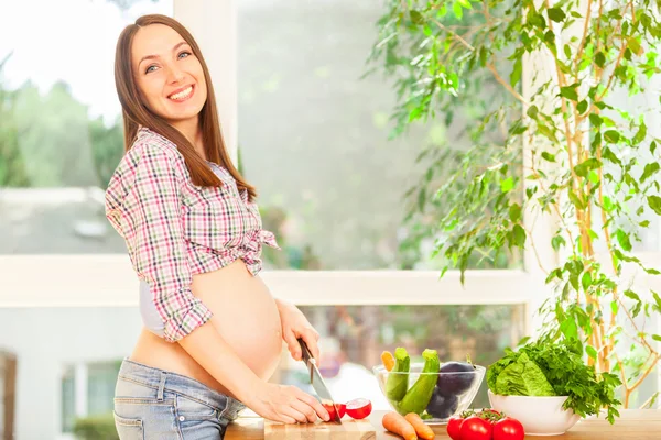 Mulher grávida está cozinhando — Fotografia de Stock