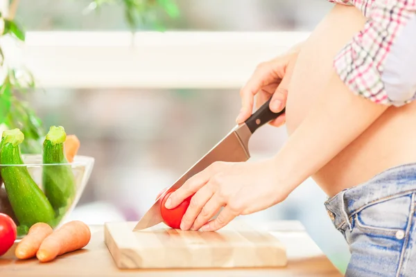 Mulher grávida está cozinhando — Fotografia de Stock