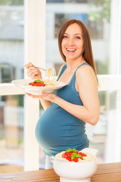 Schwangere isst riesige Portion Nudeln mit Tomatensauce — Stockfoto