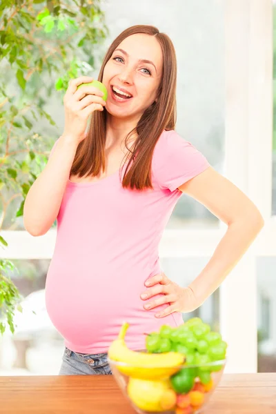 Mulher grávida comendo uma maçã — Fotografia de Stock