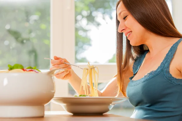 Schwangere isst riesige Portion Nudeln mit Tomatensauce — Stockfoto