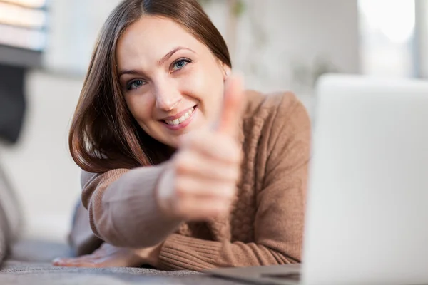 Portrait of young smiling woman looking tv at home — Stock Photo, Image
