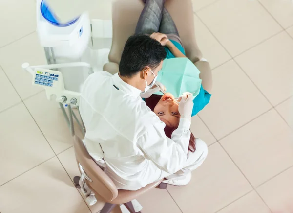 Vue du haut de dentiste asiatique faisant son travail sur une jeune femme asiatique — Photo