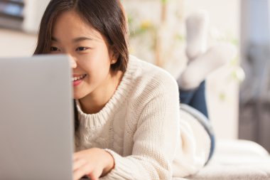 Asyalı genç kadın evde onun bilgisayar ile onun üzerinde çok çalışıyor