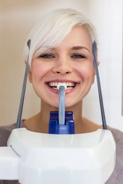 Hymyilevä blondi nainen tekee hampaiden skannauksen — kuvapankkivalokuva