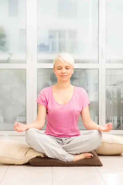 Blondýnka dělá meditace doma — Stock fotografie