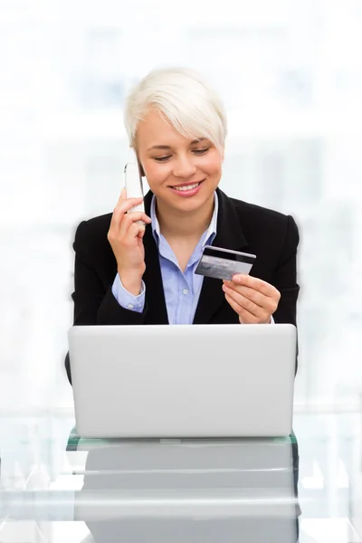 Szőke nő az online vásárlás hiteletek kártya és a telefon — Stock Fotó