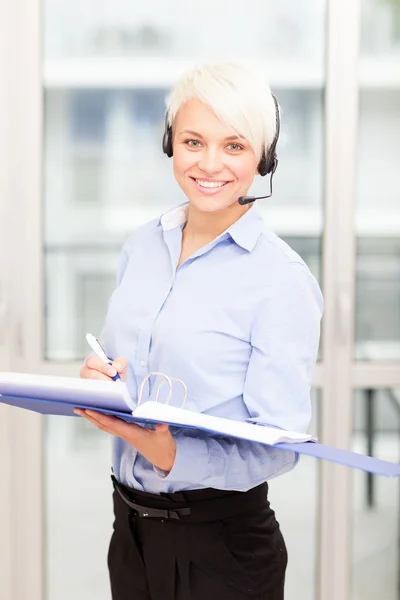 Kaukasische Geschäftsfrau steht mit Headset im Büro — Stockfoto