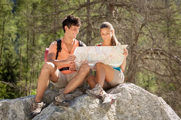 Couple is looking at the path on a map while relaxing on a big r — Stock Photo, Image