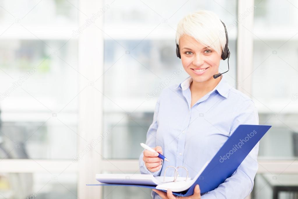 caucasian businesswoman is standing in the office with headset a