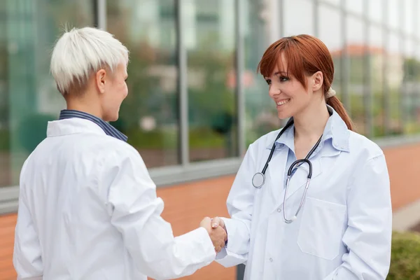 Handdruk tussen twee vrouwelijke artsen — Stockfoto