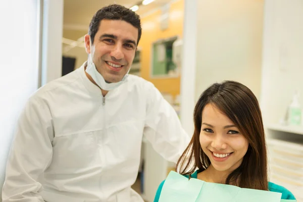 Sorrindo dentista caucasiano com bela mulher asiática olhando reboque — Fotografia de Stock