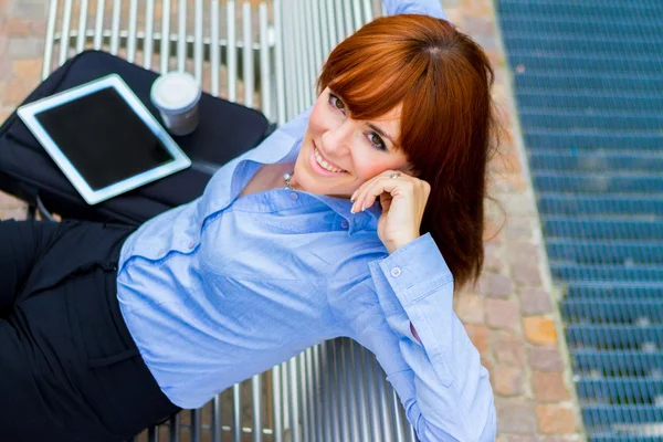Geschäftsfrau sitzt draußen auf einer Metallbank — Stockfoto