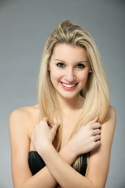 Porträt der schönen jungen blonden Frau über grauem Hintergrund — Stockfoto